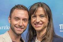 Måns Zelmerlöv standing next to Petra Mede at a press conference at the Eurovision Song Contest 2016